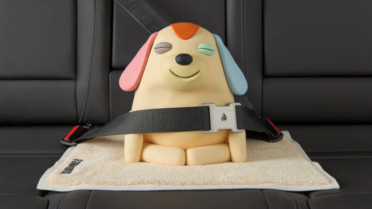 A dog riding safely in a car: seated on a towel, clipped to a seatbelt